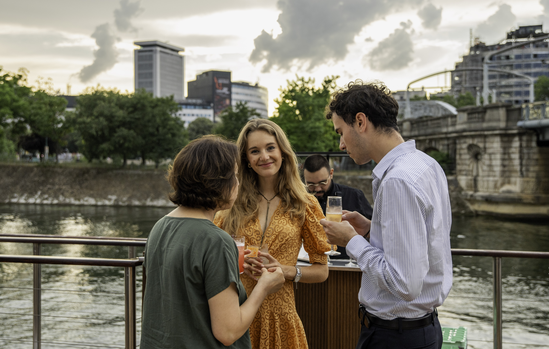 Collaborateurs en cocktail sur le pont du bateau au bord de la Seine