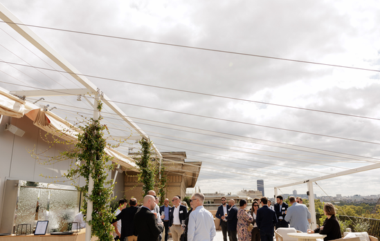 Invités du cocktail sous les voiles d'ombrage du rooftop