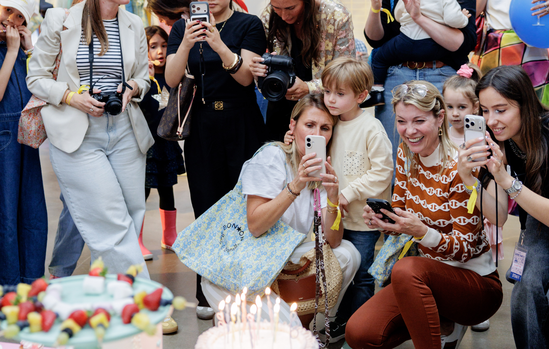 Invités et photographes autour du gâteau d'anniversaire Bonton