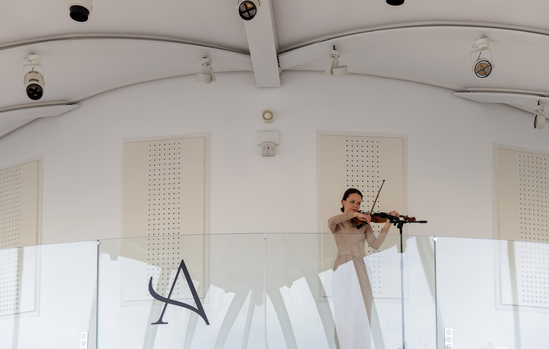 Performance de violon devant le logo Aureus