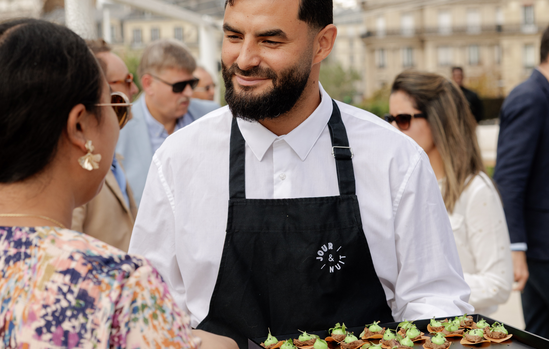 Serveur JOUR & NUIT présentant le plateau de canapés aux invités