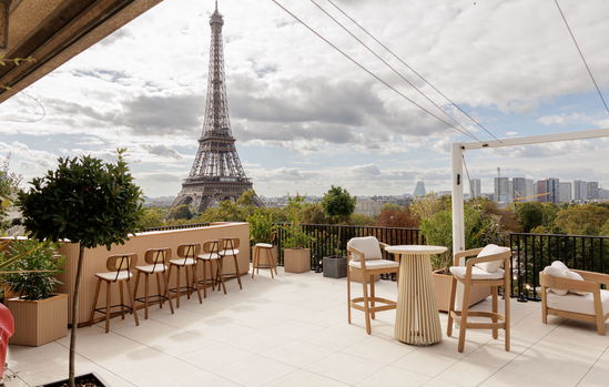 Rooftop Trocadéro avec mobilier en bois clair face à la tour Eiffel