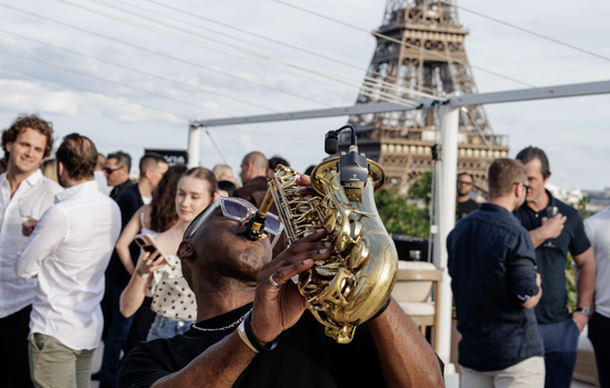 Saxophoniste en déambulation parmi les invités du side event sur le rooftop