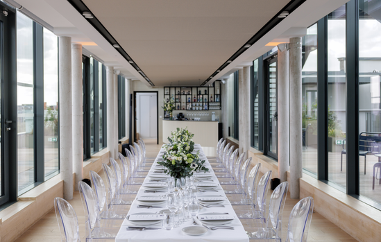 Table d'honneur dressée pour un dîner d'entreprise sur un rooftop parisien